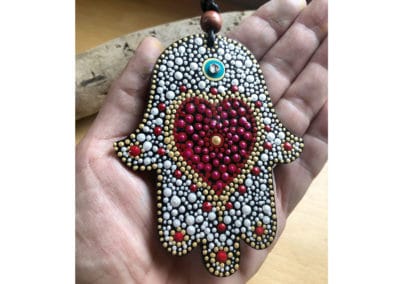 Wood Hamsa ornament dotted with red and silver paint.
