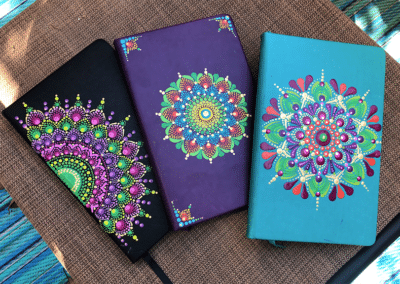 Trio of journals with brightly painted mandalas.