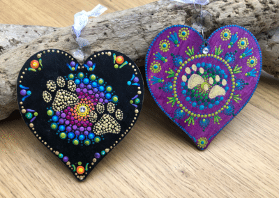 Wooden heart ornaments with mandala designs and paw print.