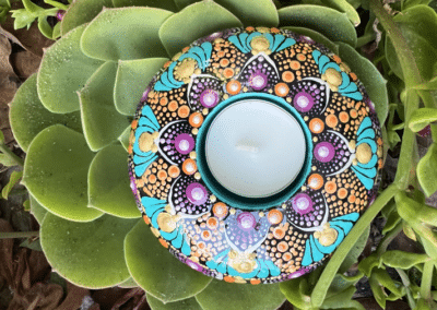 Round, hand-cast tea light holder. Bright colors used for this mandala design.