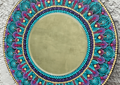 Eight inch mirror with mandala designs in magenta, teal and violet. Board is 16"