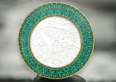Eleven inch mirror on 18" board with mandala design in greens, blues and gold.