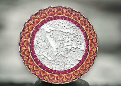 Eleven inch mirror on 18" board with mandala design in orange, reds, yellows and gold.