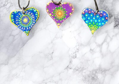 Lightweight, wooden heart pendants, acrylic paint and resin finish with a faux leather cord.